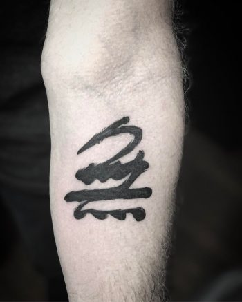 Abstract black tattoo on the forearm