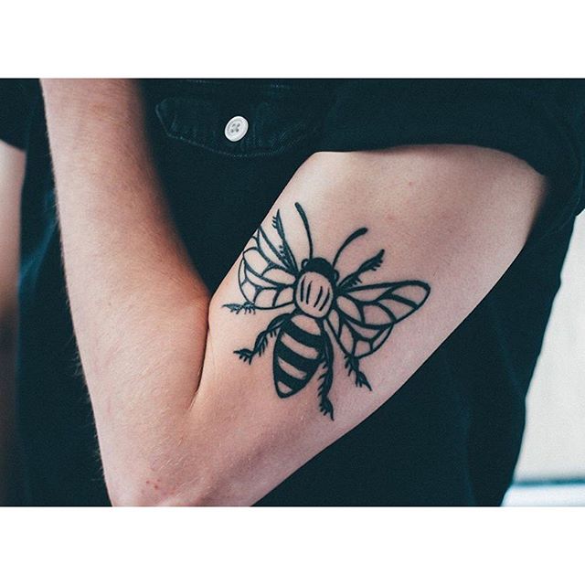 Black bee tattoo on the bicep - Tattoogrid.net