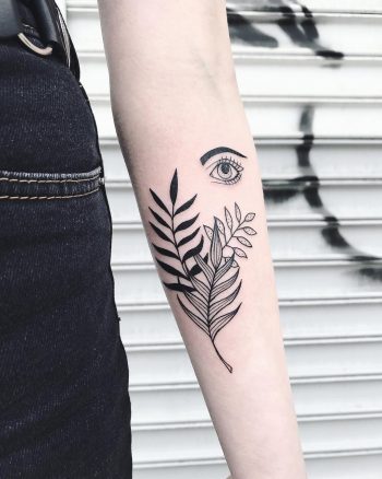 Black palm tree leaves and eye tattoo