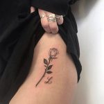Black rose and letter l tattoo on the hip