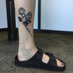 Black rose tattoo on the calf