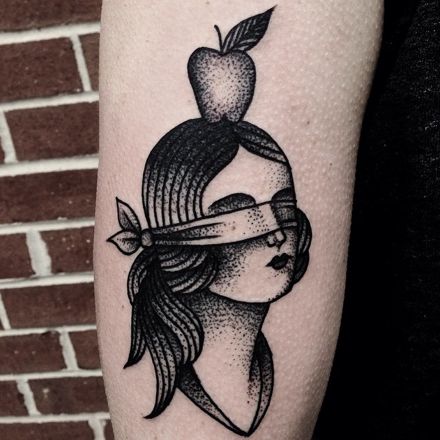 Blindfolded girl with an apple tattoo