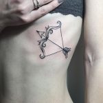 Bow and arrow tattoo on the rib cage