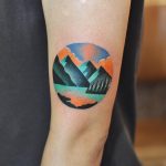 Circular mountainous landscape tattoo