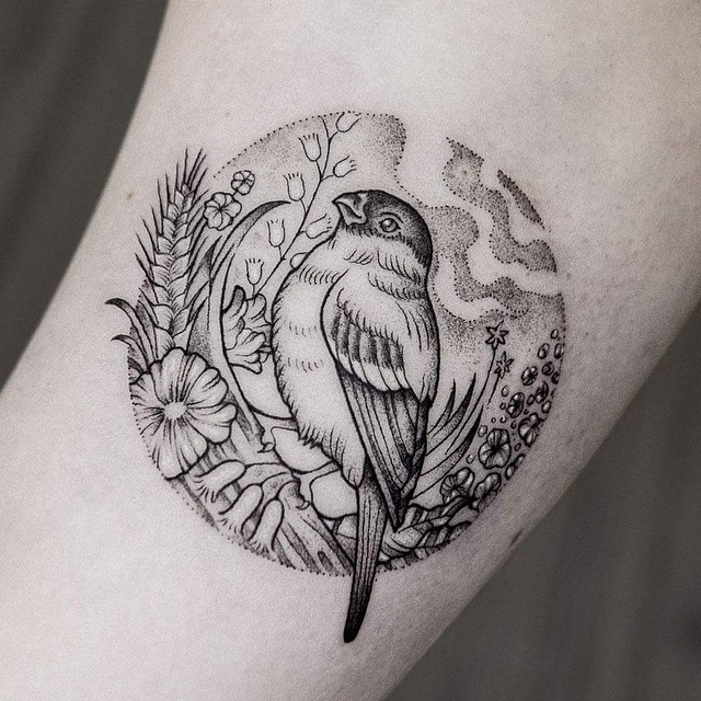 Circular tattoo of a bird on a branch