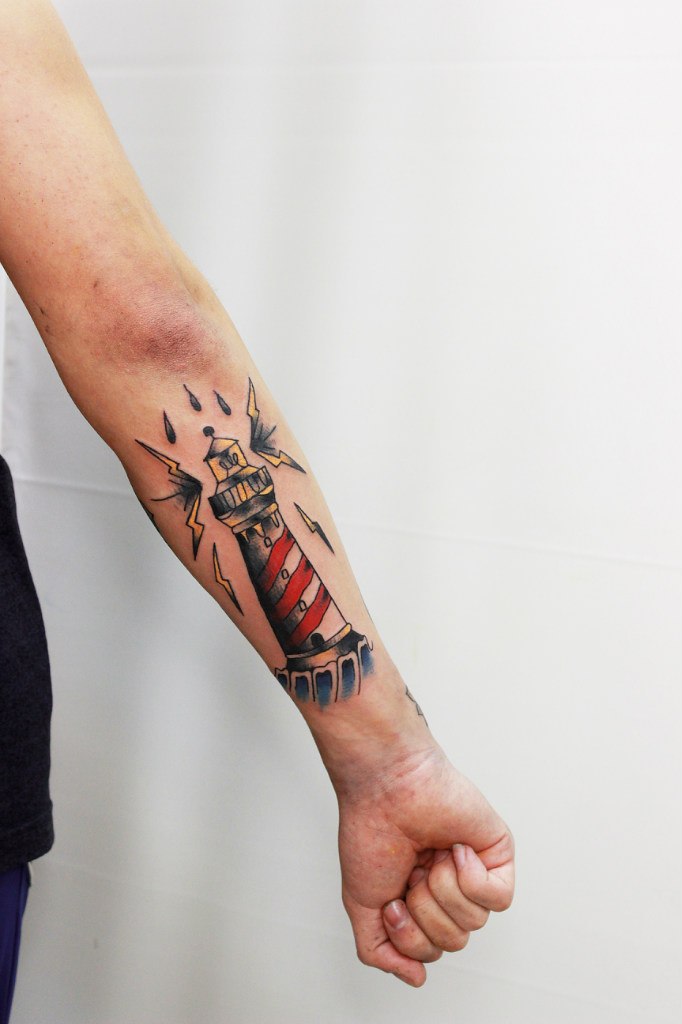 Classy lighthouse tattoo on the forearm