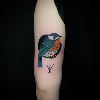 Colorful bird tattoo on the arm