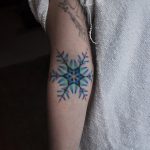 Colorful snowflake tattoo on the arm