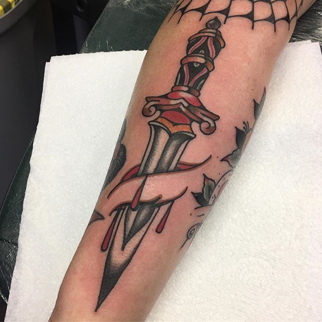 Dagger stabbed arm tattoo