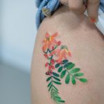 Delicate colorful flower tattoo