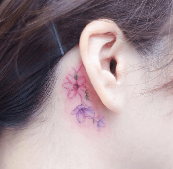 Delicate flower behind the ear tattoo