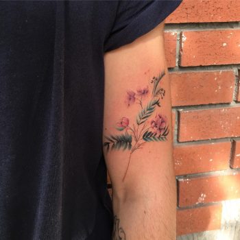 Delicate green and pink flower tattoo