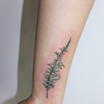 Delicate green branch tattoo