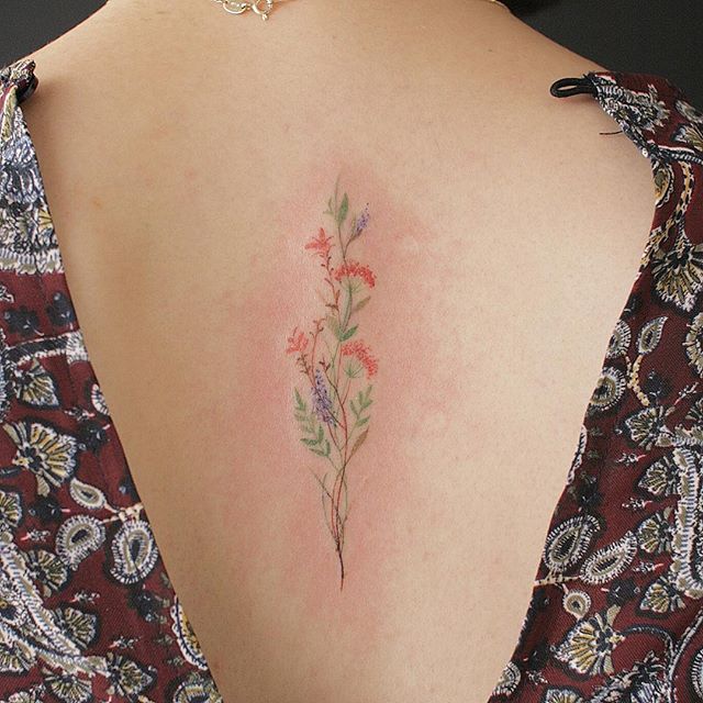 Delicate wildflower tattoo on the back