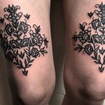 Floral ornament on tattoo on both thighs