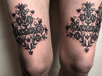 Floral ornament on tattoo on both thighs