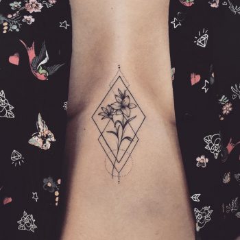 Flower in a rhombus tattoo on the sternum