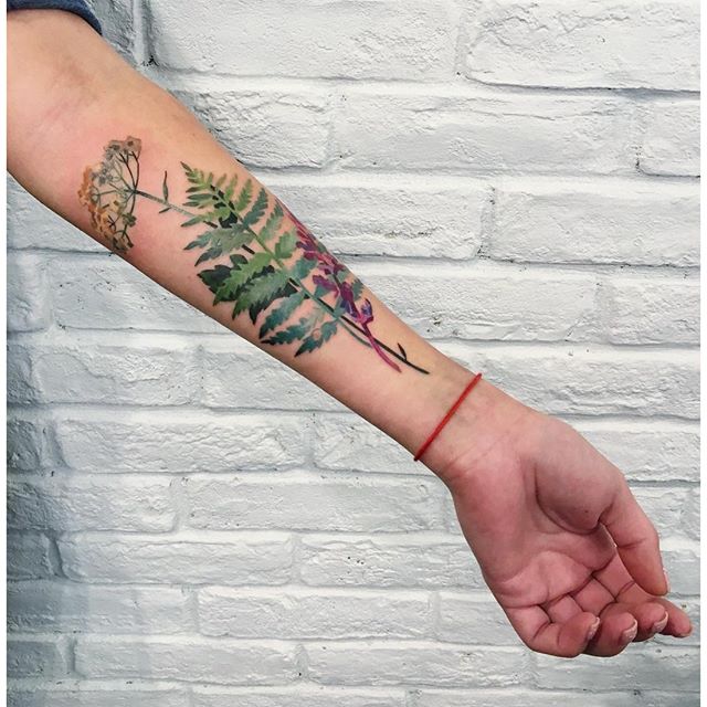 Green fern and other leaves tattoo