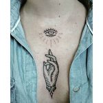 Hand and eye tattoo on the sternum