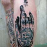 Inked hand tattoo on the left shin