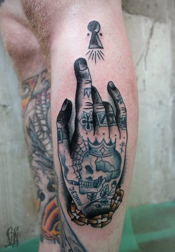 Inked hand tattoo on the left shin