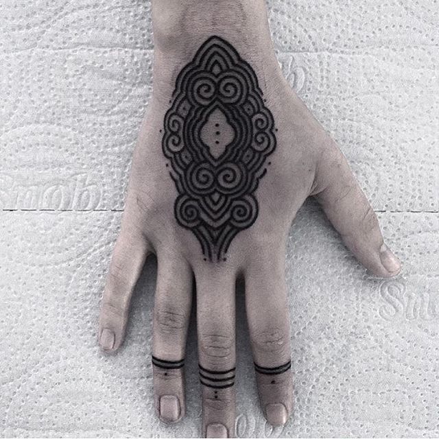 Lovely black ornament tattoo on the hand