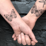 Matching butterfly tattoos on the wrists