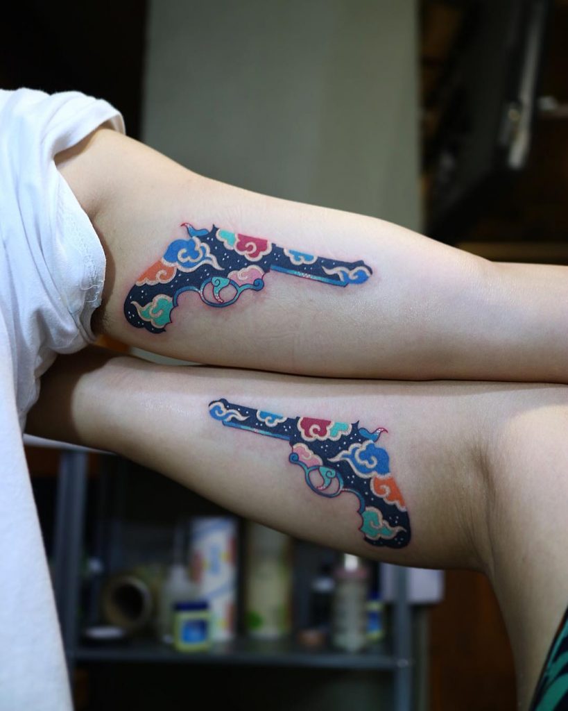 Matching floral gun tattoos