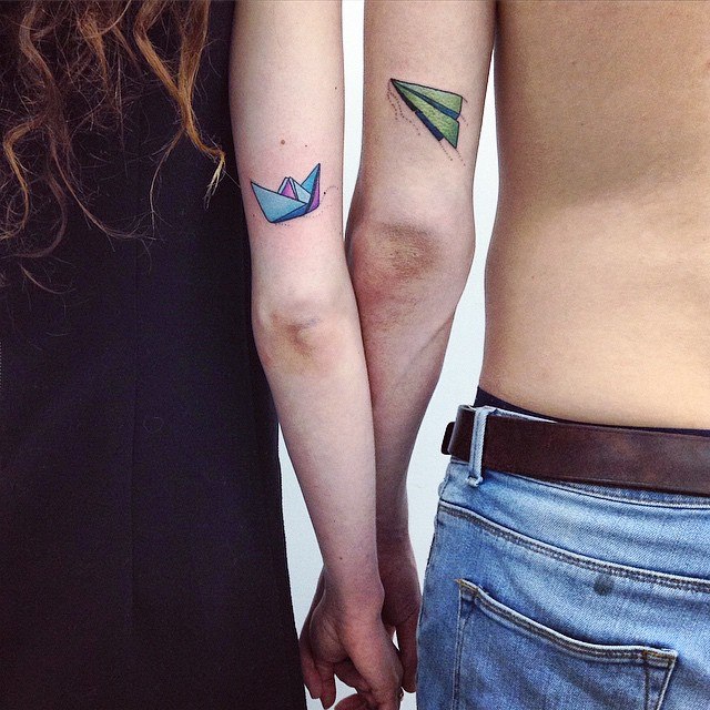 Matching paper plane and boat tattoo