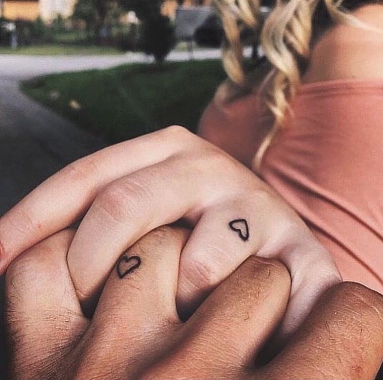 Matching tiny heart tattoos on fingers