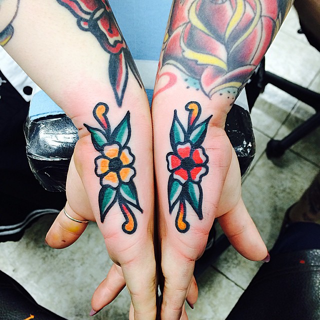 Matching traditional flower tattoos on hands