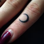 Micro crescent moon tattoo