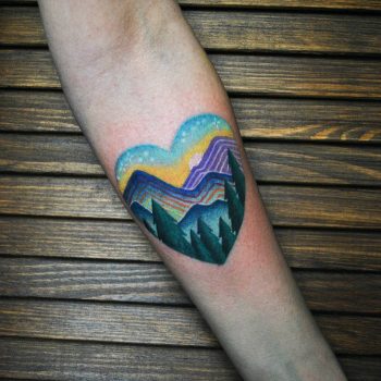 Mountainous landscape in a heart tattoo