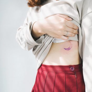 Pink crescent moon tattoo