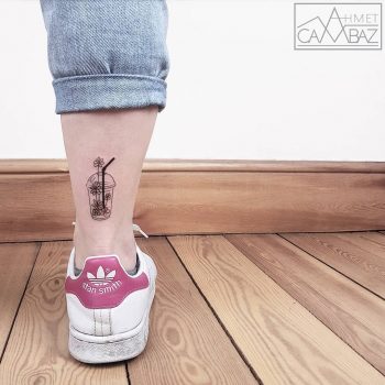 Plastic cup with flowers tattoo on the ankle