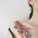 Red and black flower tattoo on the right shoulder