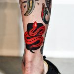 Red snake on the black background tattoo