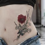 Red wildflower tattoo on the belly