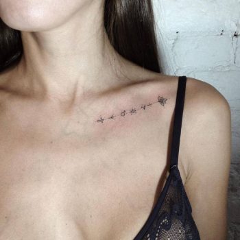 Runes and lotus flower tattoo on the clavicle bone