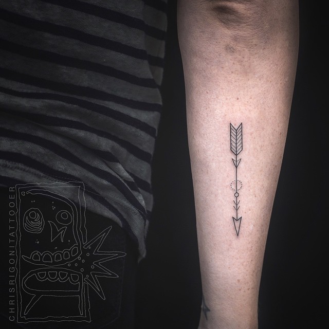 Simple and minimalist arrow tattoo on the forearm