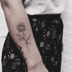 Simple black outline rose tattoo on the forearm