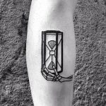 Skeleton hand and hourglass tattoo