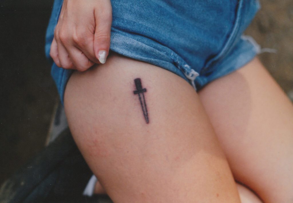 Small black dagger on the upper thigh
