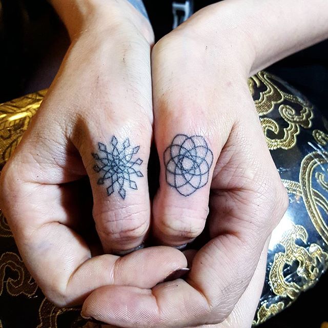 Small geoemtric tattoos on thumbs