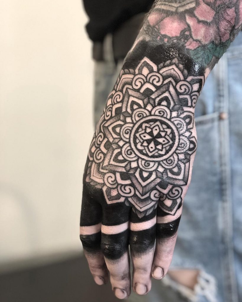 Solid black mandala tattoo on the hand