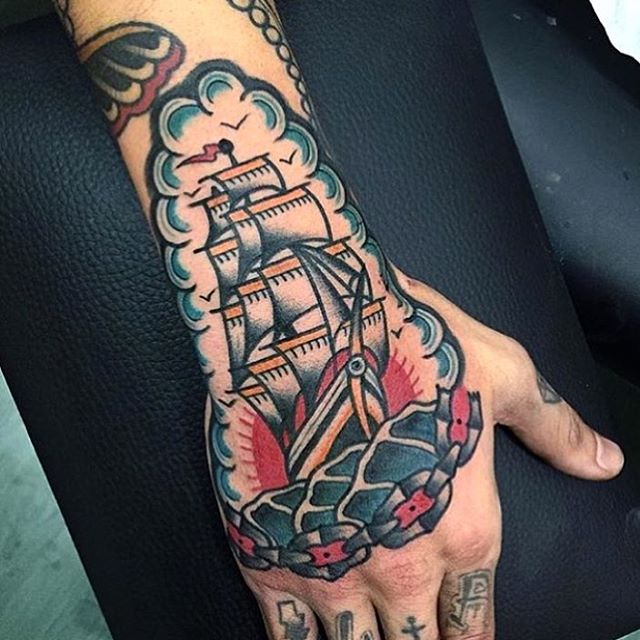 Traditional ship tattoo on the hand and forearm