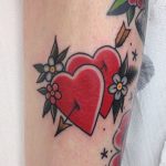 Two hearts stabbed with arrow tattoo
