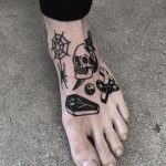 Various black tattoos on the left foot