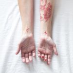 Various red tattoos on forearms