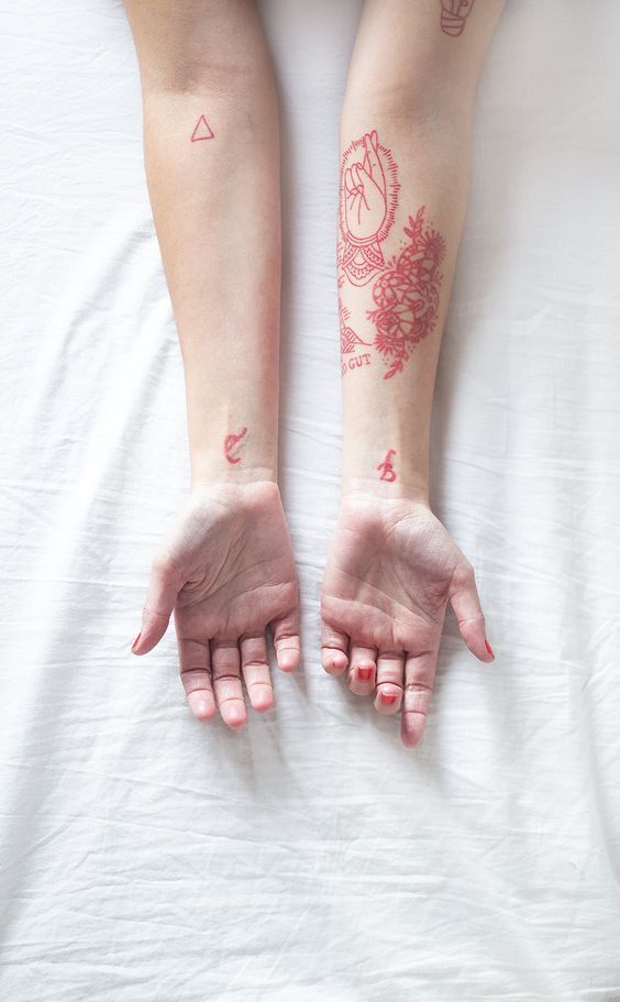 Various red tattoos on forearms